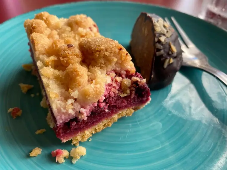 Sour cherry crumble square and a chocolate rum ball on a turquoise plate
